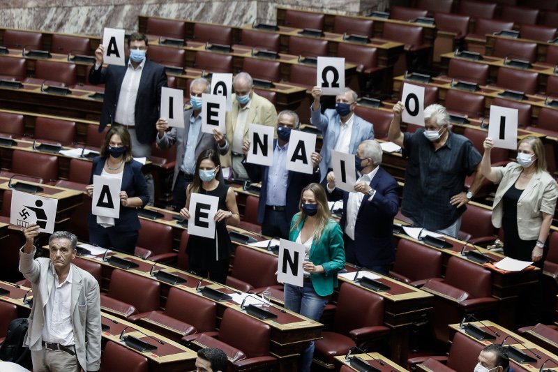 Βουλευτές του ΣΥΡΙΖΑ σηκώνουν πλακάτ κατά της Χρυσής Αυγής στη Βουλή/Φωτογραφία: EUROKINISSI/ΓΙΩΡΓΟΣ ΚΟΝΤΑΡΙΝΗΣ