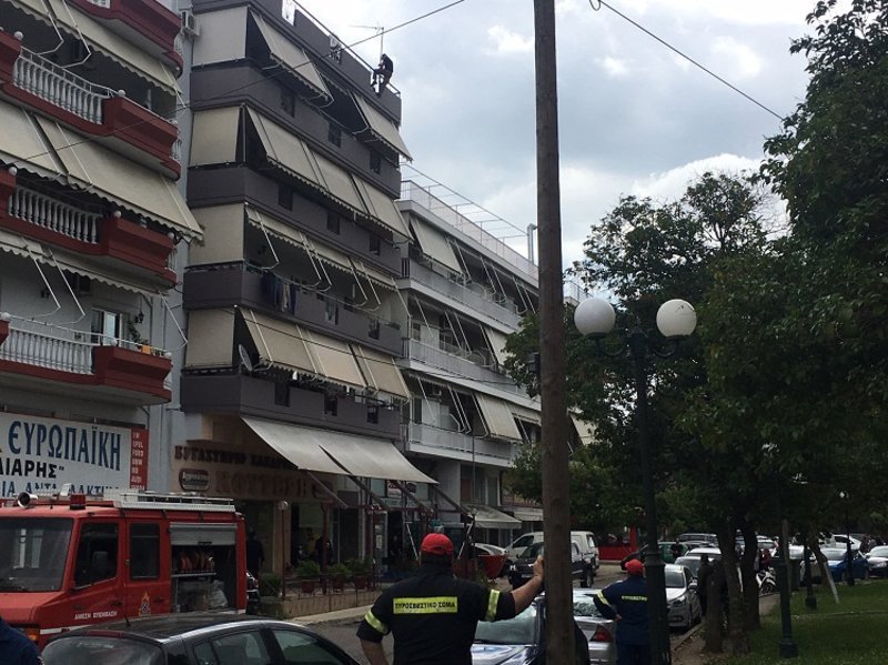 Πυροσβέστες κάτω από την πολυκατοικία όπου βρίσκεται ο νεαρός.