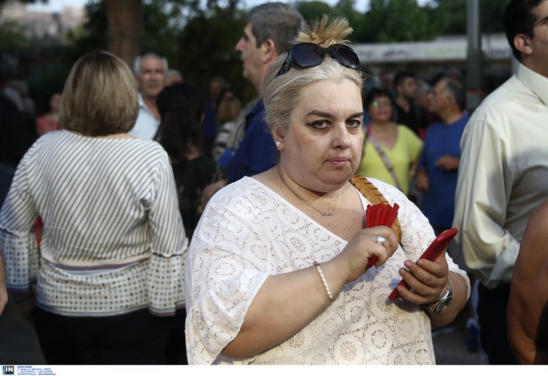 Μια κυρία με κόκκινη βεντάλια και κόκκινο κινητό