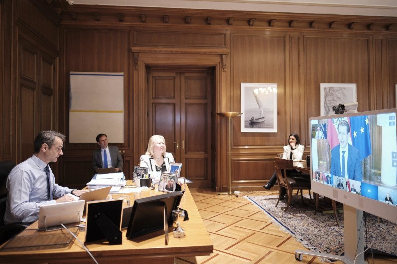 Ο Κυριάκος Μητσοτάκης στο γραφείο του εν ώρα τηλεδιάσκεψης, στην οθόνη ο Σεμπάστιαν Κουρτς