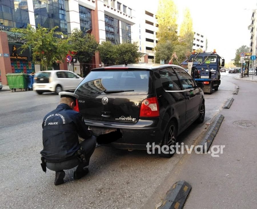 Αστυνομικός αφαιρεί την πινακίδα από παράνομα παρκαρισμένο ΙΧ