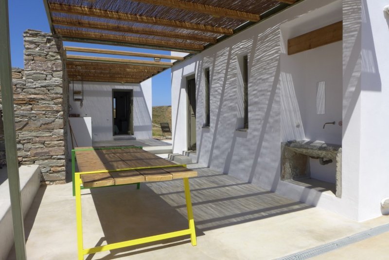 Η βεράντα του Camping House με ένα τραπέζι και μια βρύση