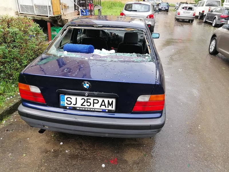 Ενα αυτοκίνητο με σπασμένα παράθυρα από το χαλάζι