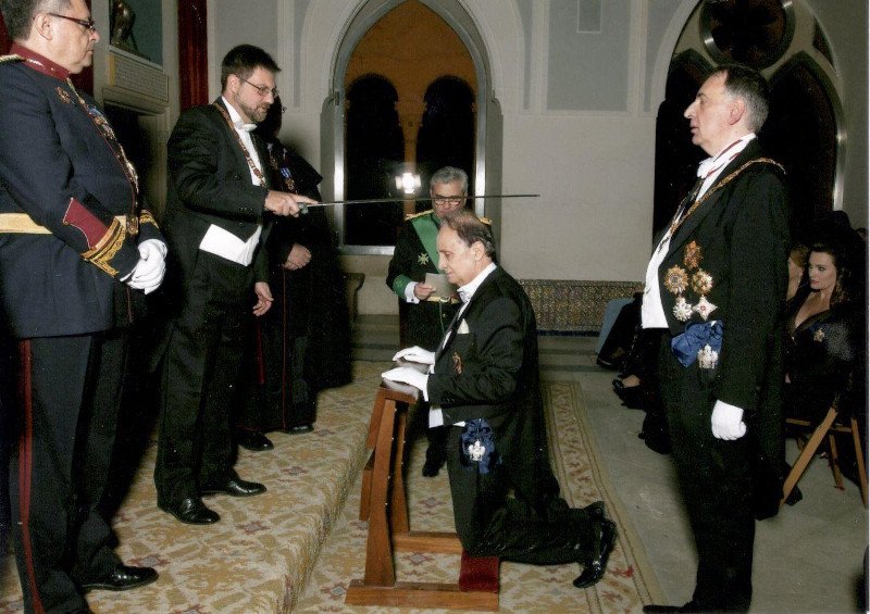 Ο κ. Γιώργος Λενός λαμβάνει το χρίσμα του Ιππότη, διά ξίφους, από τον πρίγκιπα Ερρίκο της Ισπανικής Βασιλικής Δυναστείας των Βουρβόνων, συνοδευόμενος από τον Βαρώνο Breidel