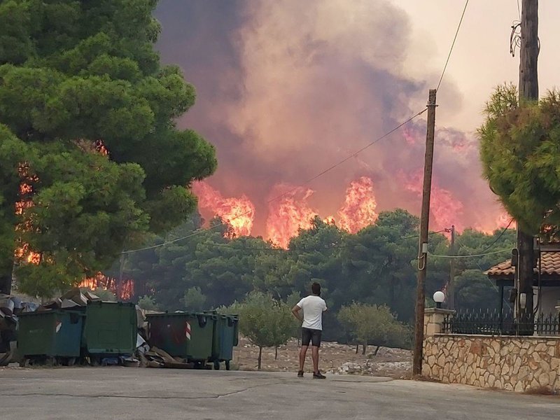 Ανήμπορος ένας κάτοικος της Ζακύνθου κοιτά τις φλόγες που κατακαίνε δίπλα στα σπίτια