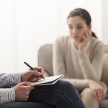 Ψυχολόγος σημειώνει καθώς μια γυναίκα κάθεται σε καρέκλα