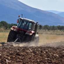 Αγρότης με τρακτέρ σε χωράφι