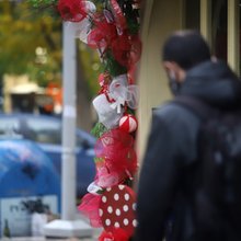 Επίδομα: Ενας άνδρας περπατά μπροστά από κατάστημα με στολισμό Χριστουγέννων