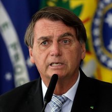 O πρώην πρόεδρος της Βραζιλίας, Ζαΐχ Μπολσονάρου μιλάει με βραζιλιάνικη σημεία πίσω του 