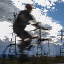 Ποδηλάτης περνά από κολώνες ηλεκτρικού ρεύματος στην Ισπανία