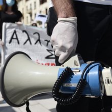 ένας άνδρας με ντουντούκα σε πορεία πρωτομαγιάς