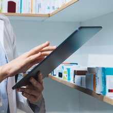 Βοηθός φαρμακείου δίπλα σε φάρμακα