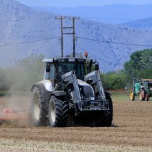Αγρότης με το τρακτέρ στο χωράφι