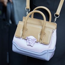 Γυναίκα με δερμάτινη τσάντα Versace με το χαρακτηριστικό κεφάλι της Μέδουσας