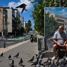 Άνδρας στο Τελ-Αβίβ του Ισραήλ ταΐζει πουλιά την επομένη της συμφωνίας για εκεχειρία με το Ιράν