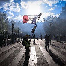 Άνδρας κρατάει τη γαλλική σημαία σε δρόμο του Παρισιού