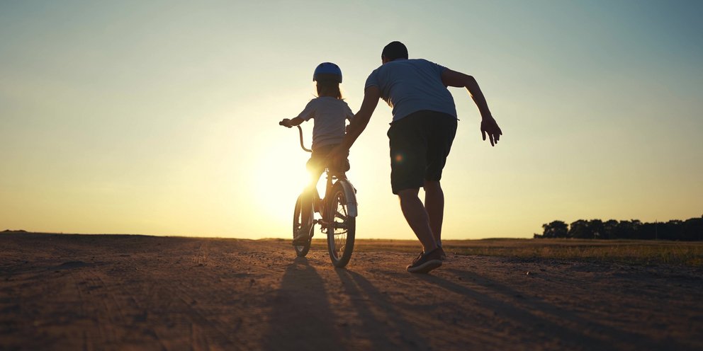 Πατέρας βοηθά παιδί να μάθει ποδήλατο