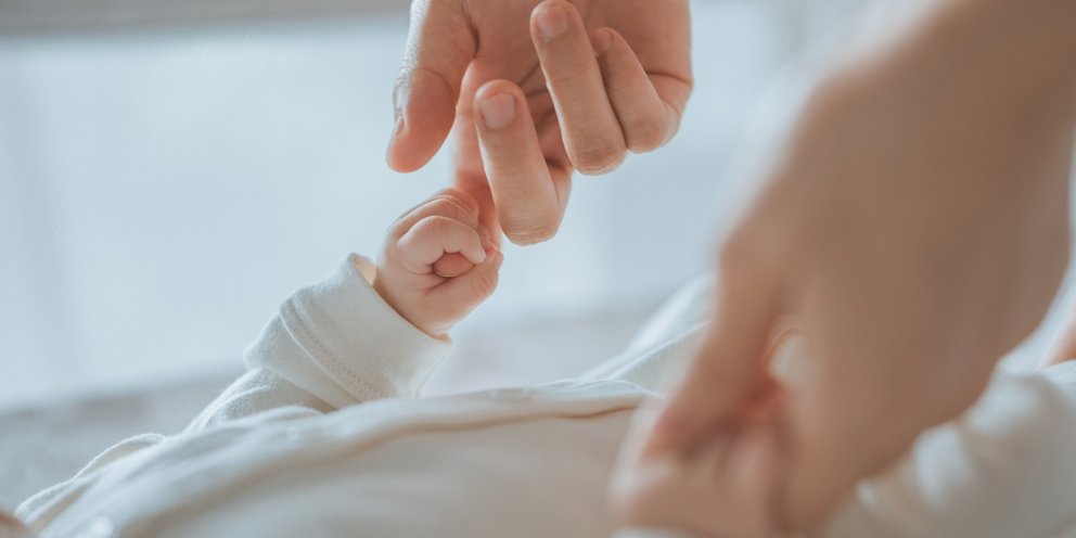 Μητέρα κρατά τα χεράκια του μωρού της