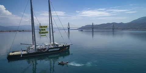 To Rainbow Warrior της Greenpeace με φόντο τη γέφυρα Ρίου – Αντιρρίου