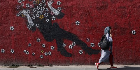 Μια Ιρανή περπατά δίπλα σε ένα γκράφιτι σε δρόμο της Τεχεράνης 