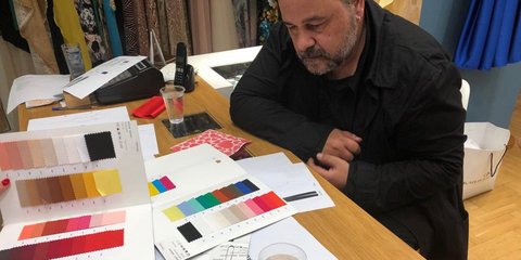 Ο Αλέξανδρος Ρήγας σε ένα γραφείο μπροστά σε χρωματολόγιο