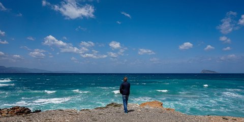 Ανδρας μπροστά στη θάλασσα που αρχίζεινα φουρτουνιάζει