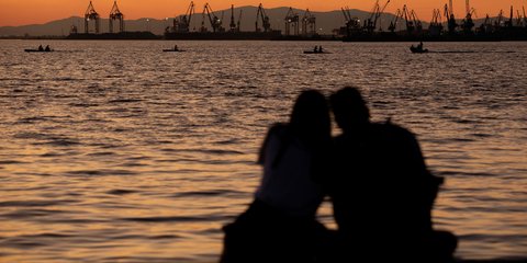 Ζευγάρι απολαμβάνει αγκαλιά το ηλιοβασίλεμα στο Θερμαϊκό