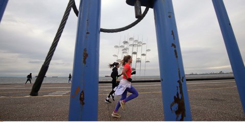 Τζόκινγκ μπροστά από το γλυπτό Ζογγολόπουλου στην παραλία Θεσσαλονίκης, πίσω από τα κάγκελα