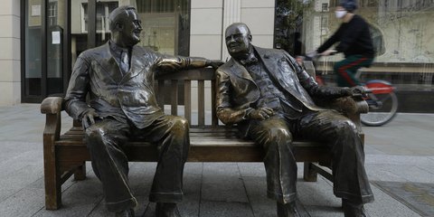 Ποδηλάτης με μάσκα περνά πίσω από τα αγάλματα των Τσώρτσιλ και Ρούσβελτ στο Λονδίνο