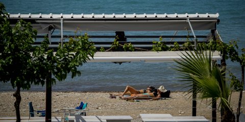 Το καλοκαίρι χτυπάει την πόρτα μας : Δύο γυναίκες κάνουν ηλιοθεραπεία στην παραλία του Φαλήρου 