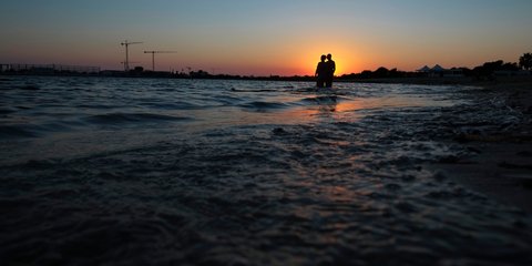 Ενα ζευγάρι μέσα στη θάλασσα, απολαμβάνει το ηλιοβασίλεμα στην Αγία Νάπα της Κύπρου