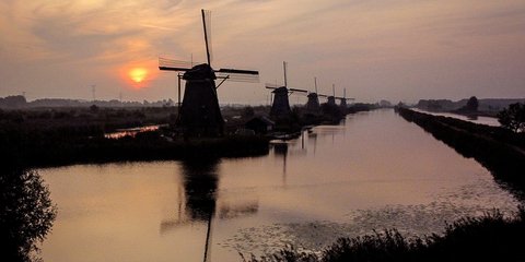 Η ανατολή του ήλιου πίσω από τους ανεμόμυλους στο Kinderdijk της Ολλανδίας