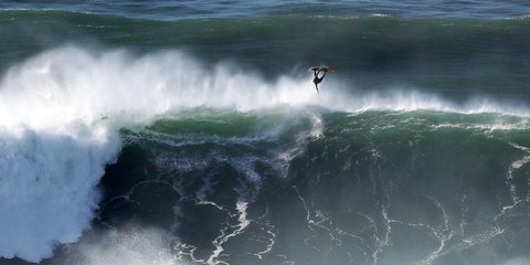 Ενας σέρφερ παίρνει κεφάλι από ένα τεράστιο κύμα στο Praia do Norte της Πορτογαλίας