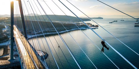 Ιλιγγος: Εργάτες καθαρίζουν από τον πάγο τα καλώδια εναέριας γέφυρας στη Ρωσία