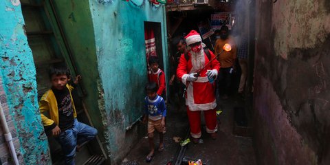 Ενας άνδρας ντυμένος Αϊ-Βασίλης, μοιράζει δώρα σε παιδιά της Ινδίας, εν μέσω πανδημίας