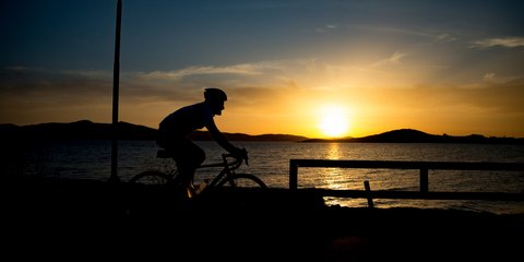 Ποδηλάτης αθλείται με φόντο το ηλιοβασίλεμα στη Νάξο