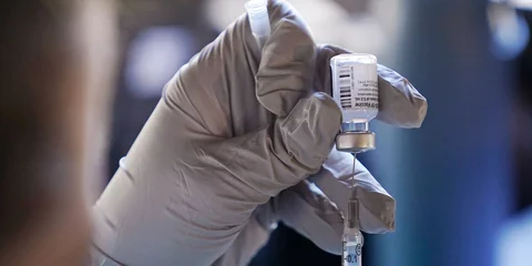 εμβόλιο COVID-19 σε χέρια νοσηλευτή με λευκά γάντια