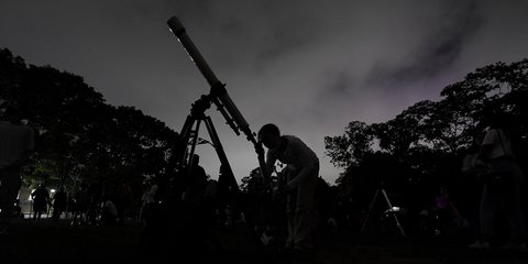 Ένα κορίτσι κοιτάζει μέσα από το τηλεσκόπιο το πρώτο «Ματωμένο Φεγγάρι» της χρονιάς, στο Καράκας της Βενεζουέλας / AP