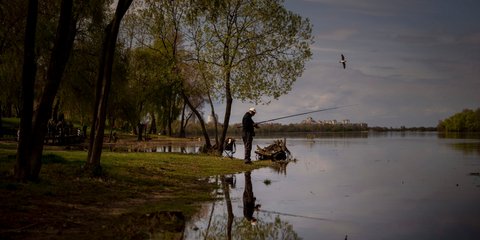 Άντρας ψαρεύει στον ποταμό Δνείπερο καθώς ρέει μέσα από το Κίεβο