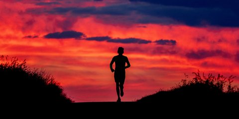 Ένας άνδρας στη Φρανκφούρτη τρέχει με φόντο την κατακόκκινη αυγή