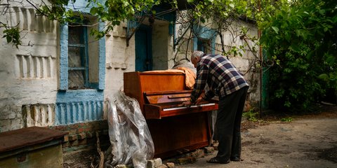 Ο Ουκρανός Anatolii Virko παίζει πιάνο έξω από ένα κατεστραμμένο από τους ρωσικούς βομβαρδισμούς σπίτι 