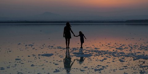 Μητέρα με την κόρη της εκστατικές στη δύση του ηλίου στην Κύπρο