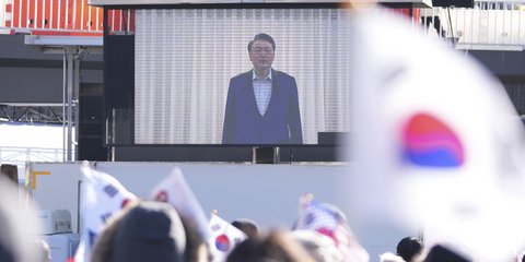 Μια τεράστια οθόνη προβάλλει πλάνα από τον έκπτωτο πρόεδρο της Νότιας Κορέας Γιουν Σουκ Γιολ