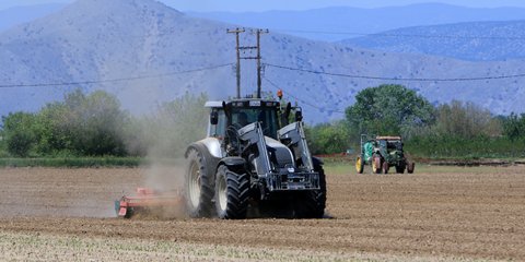 Αγρότης με το τρακτέρ στο χωράφι