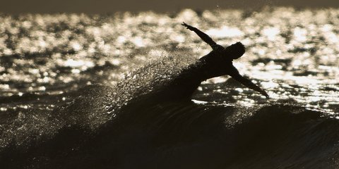 Σέρφερ κάνει ακροβατικά πάνω στο κύμα