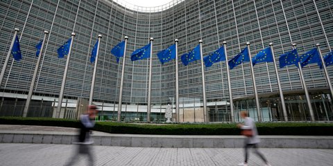 Σημαίες της Ευρωπαϊκής Ένωσης κυματίζουν ενώ πεζοί περπατούν μπροστά από την έδρα της ΕΕ στις Βρυξέλλες 