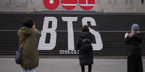 Πεζοί σταματούν για να τραβήξουν φωτογραφίες στα τεράστια γράμματα του συγκροτήματος K-pop BTS στο κέντρο της Σεούλ – Φωτ: ΑΡ