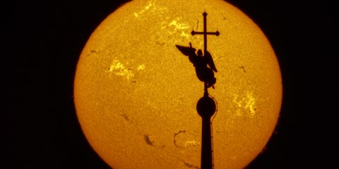 Σκιά ανεμοδείκτη σε μορφή αγγέλου διαγράφεται μπροστά από τον ήλιο / Φωτογραφία: AP/Dmitri Lovetsky