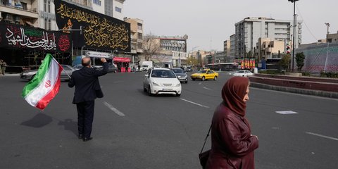 Άνδρας με σημαία του Ιράν στο κέντρο της Τεχεράνης