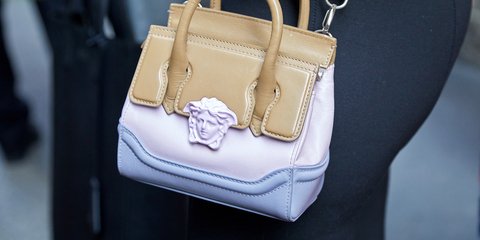 Γυναίκα με δερμάτινη τσάντα Versace με το χαρακτηριστικό κεφάλι της Μέδουσας